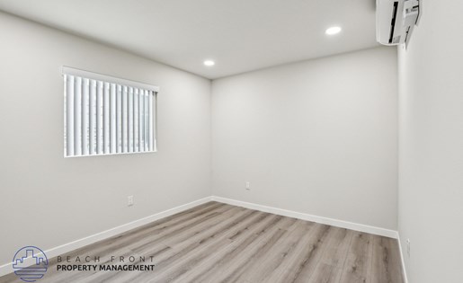 A room with a window and wooden flooring.